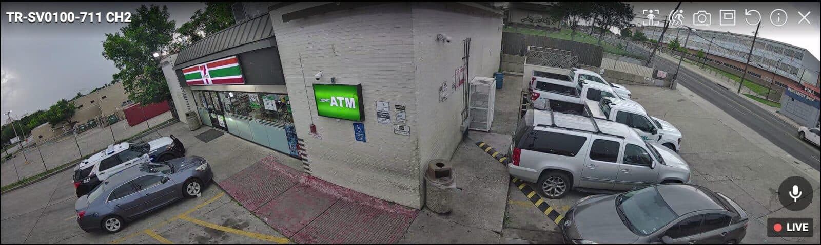 Sharpvue Panoramic 180° camera — stitched dual-sensor view of a storefront and parking lot, edge to edge