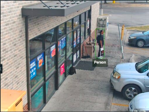 Sharpvue Speed Dome 25X — live view of a convenience-store entrance and parking lot from a trailer mast, with AI person detection boxed on a visitor at the door